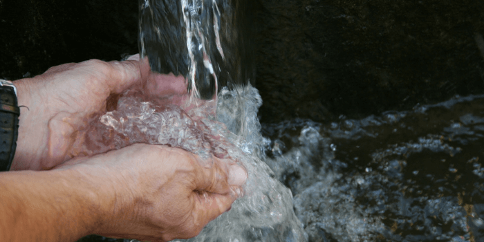 Quellwasser fließt in geöffnete Hände