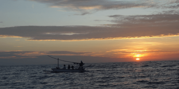 Fischerboot bei Sonnenaufgang auf dem Meer