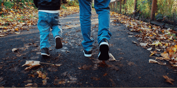 Vater und Sohn laufen auf Waldweg nebeneinander
