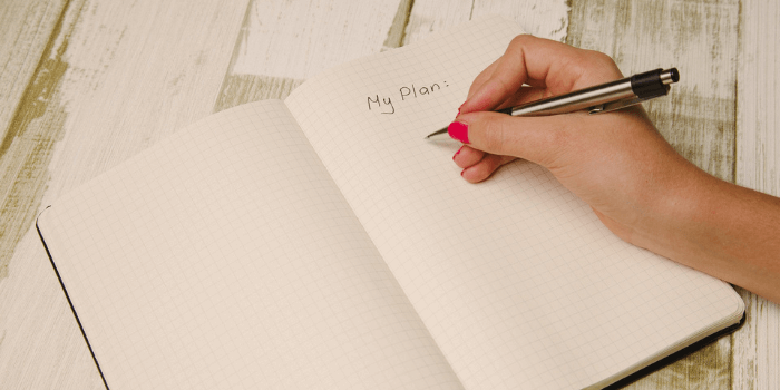 Frau schreibt in Buch: My Plan