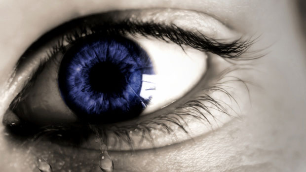 Ein tränendes Auge mit blauer Pupille