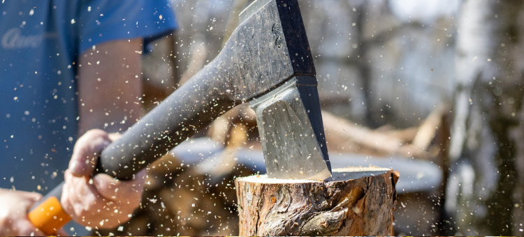 Eine Axt in der Hand die Holz spaltet