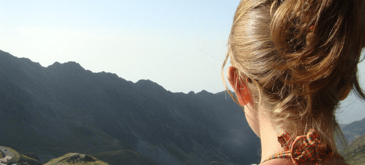 Erfahrungsbricht, Frau mit Blick auf hohe Berge