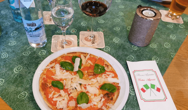 Bild 12: Pizza, Wein und Wasser auf dem Tisch während des Klassentreffens
