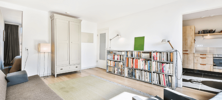 Wohnzimmer mit Bücherregal und Sicht in die Küche