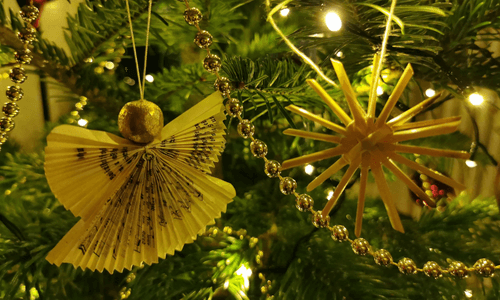 Jahresrückblick 2022, ein Engel und ein Strohstern am Christbaum mit Lichterkette