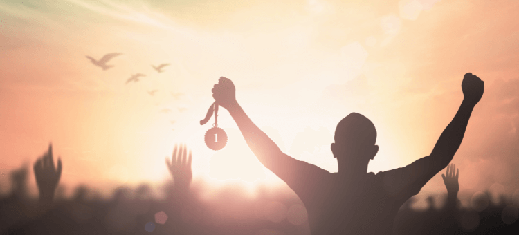 Mach dein Ding - Mann reißt jubelnd seine Arme hoch, hat Medaille in linker Hand, vögel fliegen am Himmel