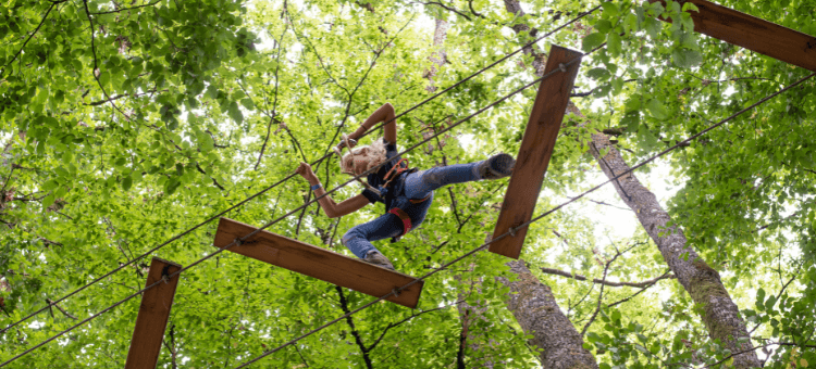 Wenn nicht ohne Angst, dann  mit. Hier im Klettergarten beim überqueren von Holzbrettern in großer Höhe