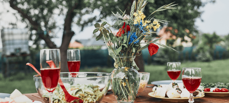 Das Festmahl: Ein gedeckter Tisch mit Gläsern, Teller und Schüsseln im Freien