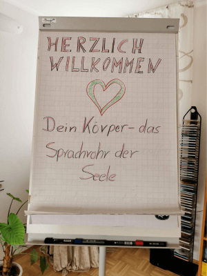 Herzliche willkommen steht auf einer Flipchart