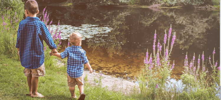 Älterer Bruder führt jüngeren Bruder an der Hand