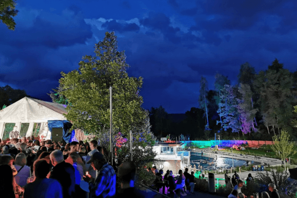 Viele Menschen feiern das Nachtbaden im Schwimmbad