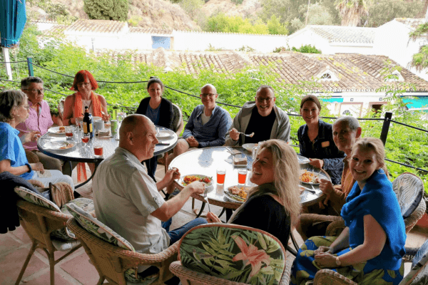Seminarteilnehmer sitzen beim Essen am Tisch auf der Terrasse