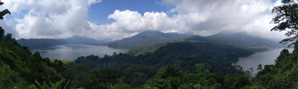 Wie Bali im Landesinneren aussieht: Hier zwei sehen von oben betrachtet. Blauer Himmel mit weißen Wolken, im Vordergrund grüner Dschungel