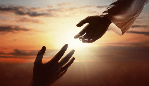 Botschaft von Jesus dem Christus: Zwei Hände begegnen sich vor der untergehenden Sonne