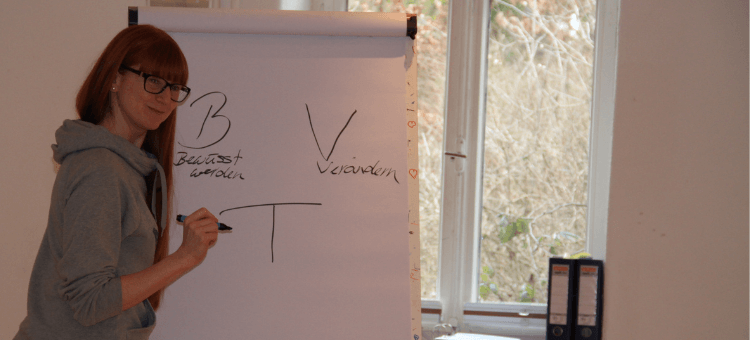 BVT - Bewusstwerden, verändern, trainieren. Eine Teilnehmerin schreibt das auf die Flipchart