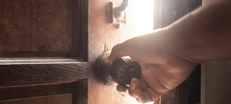 Tür wird am Knauf geöffnet, dahinter Licht