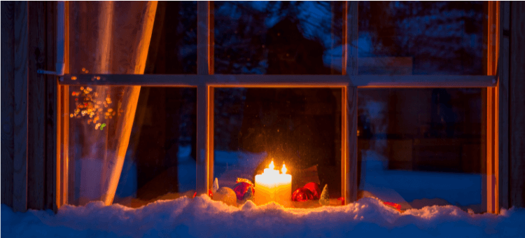 Kerze im Fenster erhellt die Dunkelheit