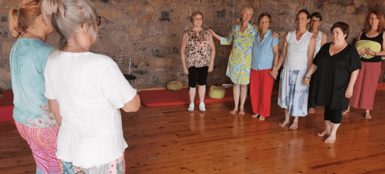 Teilnehmer stehen in einer Familienaufstellung im Kreis während eines Seminars